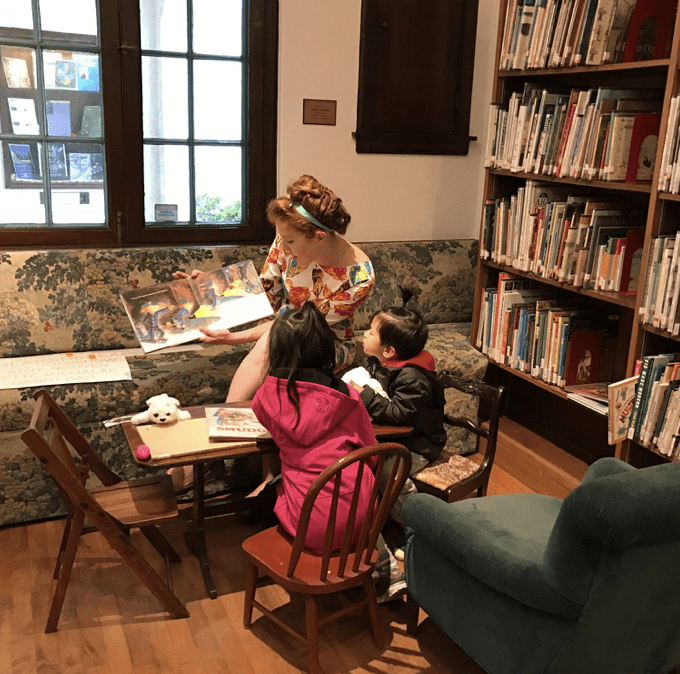 A woman reading a story to children.